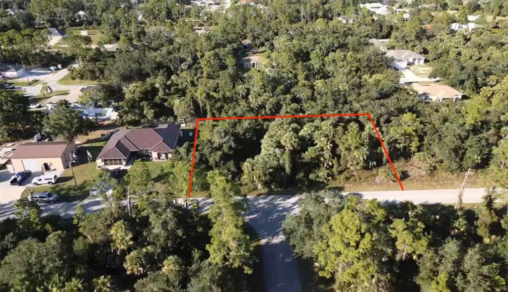 An aerial view shows a wooded, undeveloped rectangular lot outlined in red next to a house — Lot 5 & 6 COUNTESS AVENUE, NORTH PORT, FL
