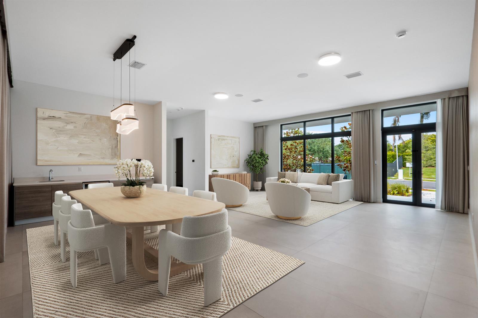 A modern open-concept living and dining area with light wood furniture, neutral decor, and floor-to-ceiling windows — 16788 Natures Way, Weston FL 33326, WESTON, FL