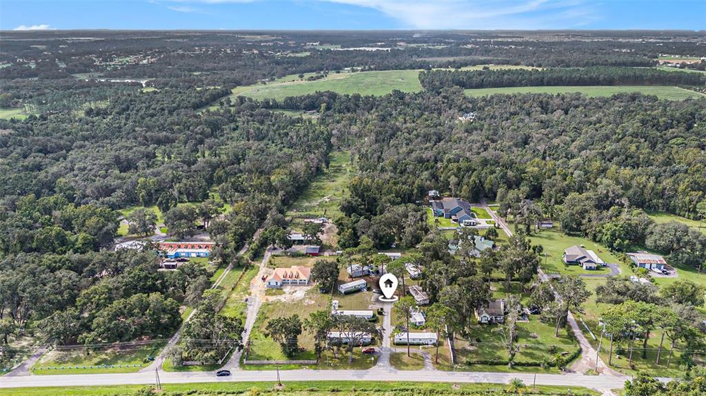 An aerial view shows a rural property with several mobile homes and outbuildings among trees — 14638 TREELEAF LANE, DADE CITY, FL