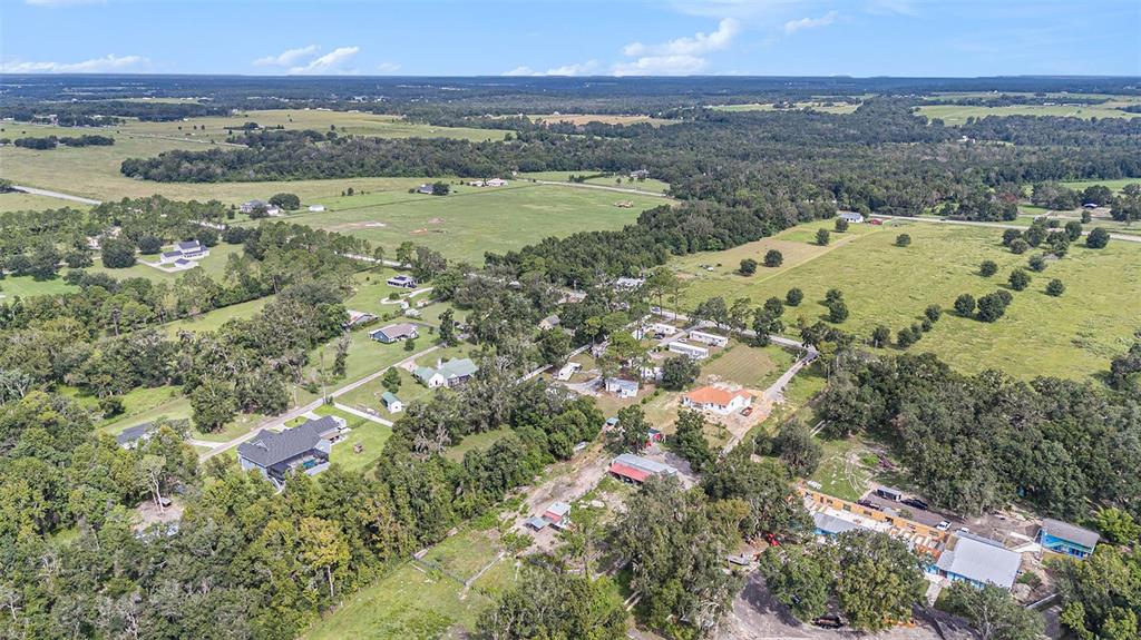 An aerial view shows a rural residential area with scattered houses, trees, and open fields — 14638 TREELEAF LANE, DADE CITY, FL