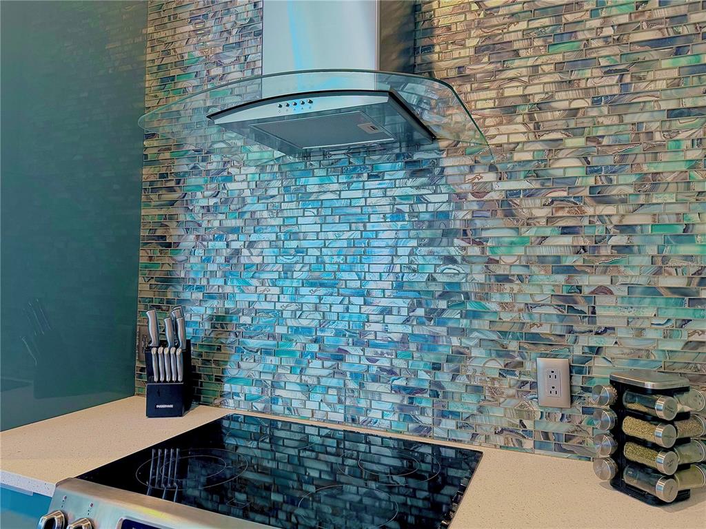 A kitchen features a blue and brown mosaic tile backsplash above a glass cooktop — 1238 E KENNEDY BOULEVARD UNIT 1001, TAMPA, FL