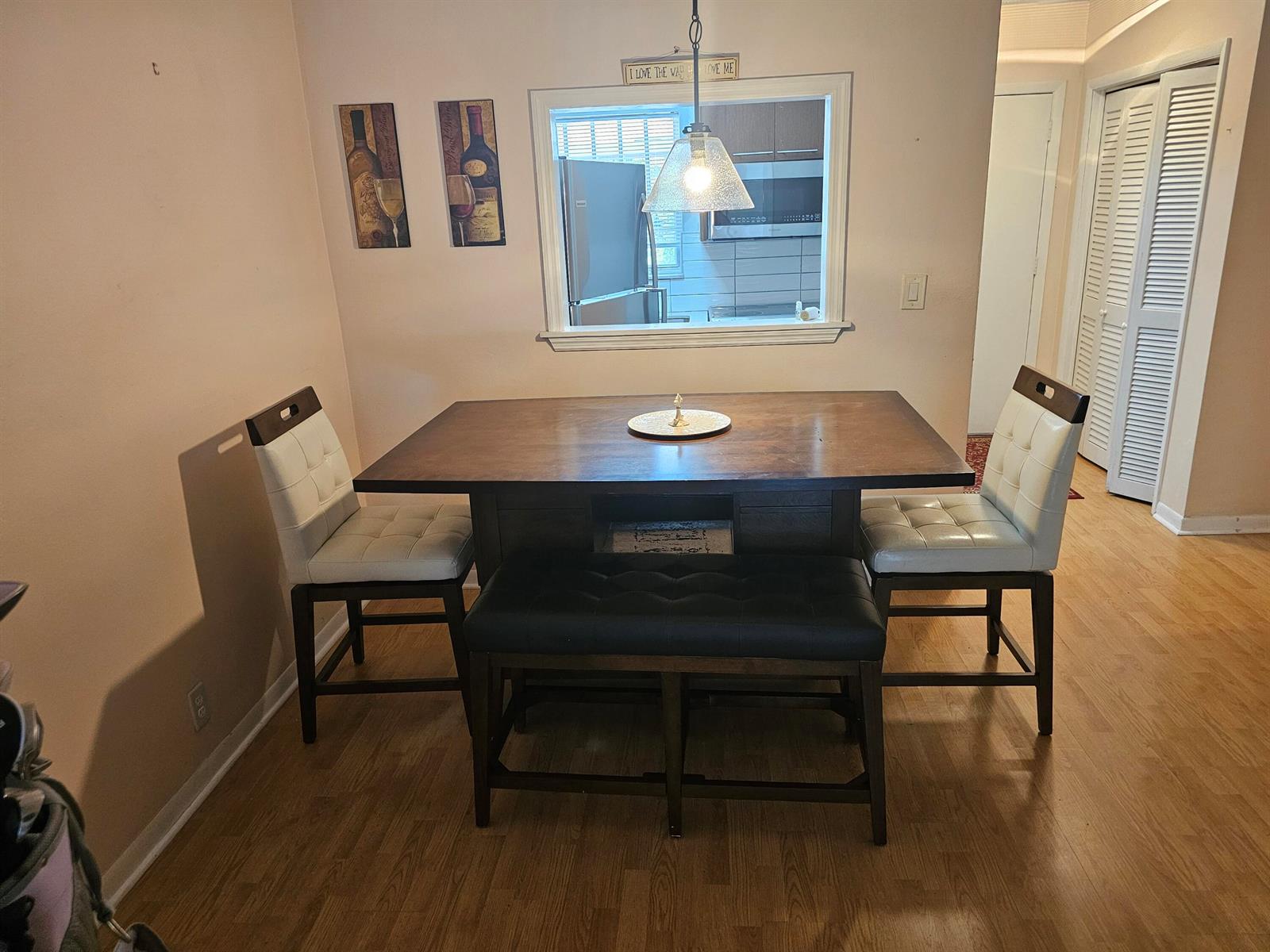 A dining area features a wooden table with two white chairs and a black bench — 2475 W Golf Boulevard # 243, Pompano Beach FL 33064, POMPANO BEACH, FL