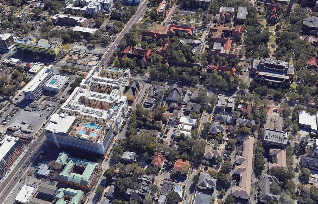 An aerial view shows a dense urban neighborhood with apartment complexes, historic buildings, and trees — 210 NW 15TH STREET, GAINESVILLE, FL