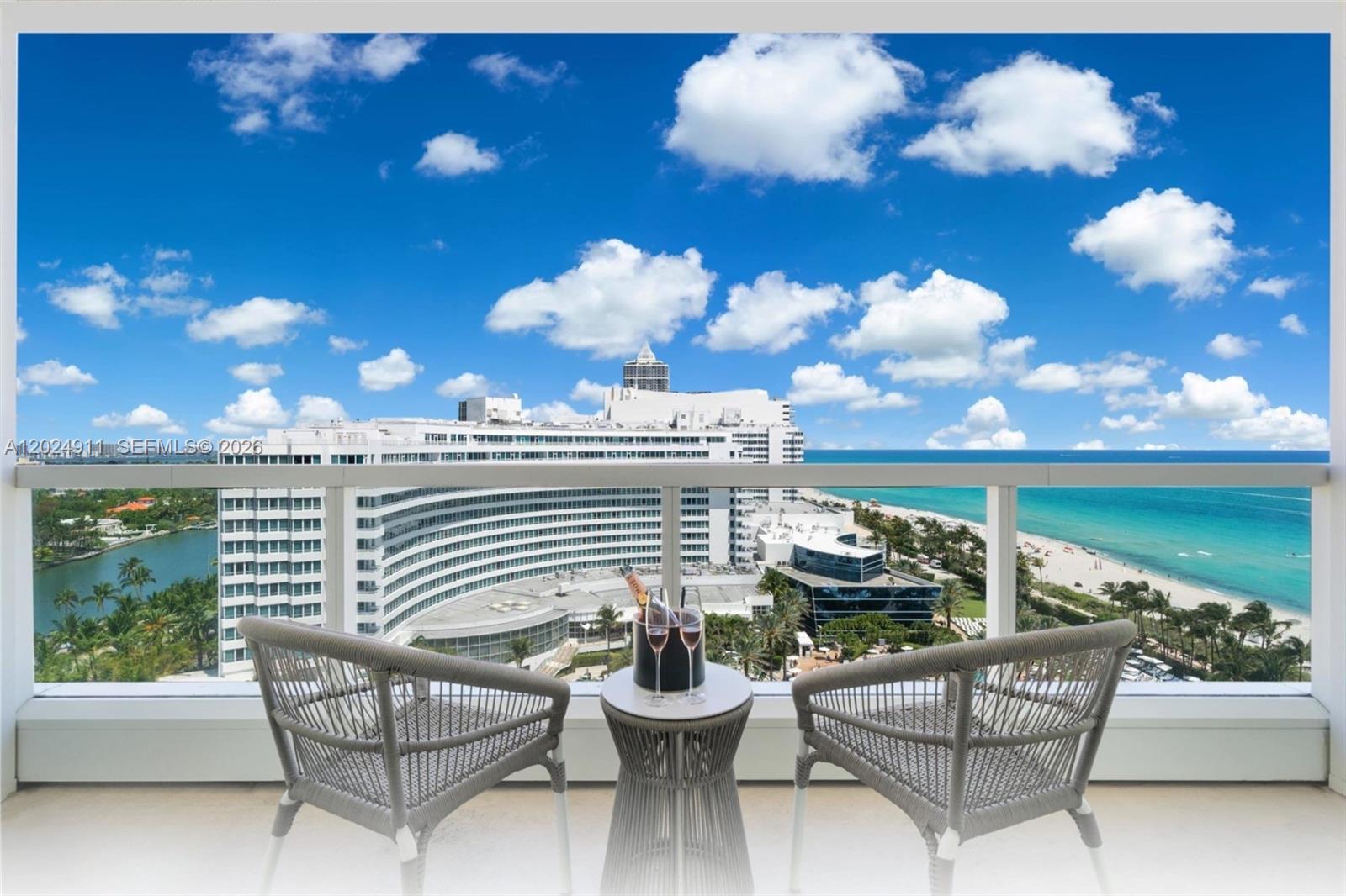 A balcony with two chairs and a small table overlooks a beach and ocean — 4391 Collins Ave # 1002, Miami Beach FL 33140, MIAMI BEACH, FL
