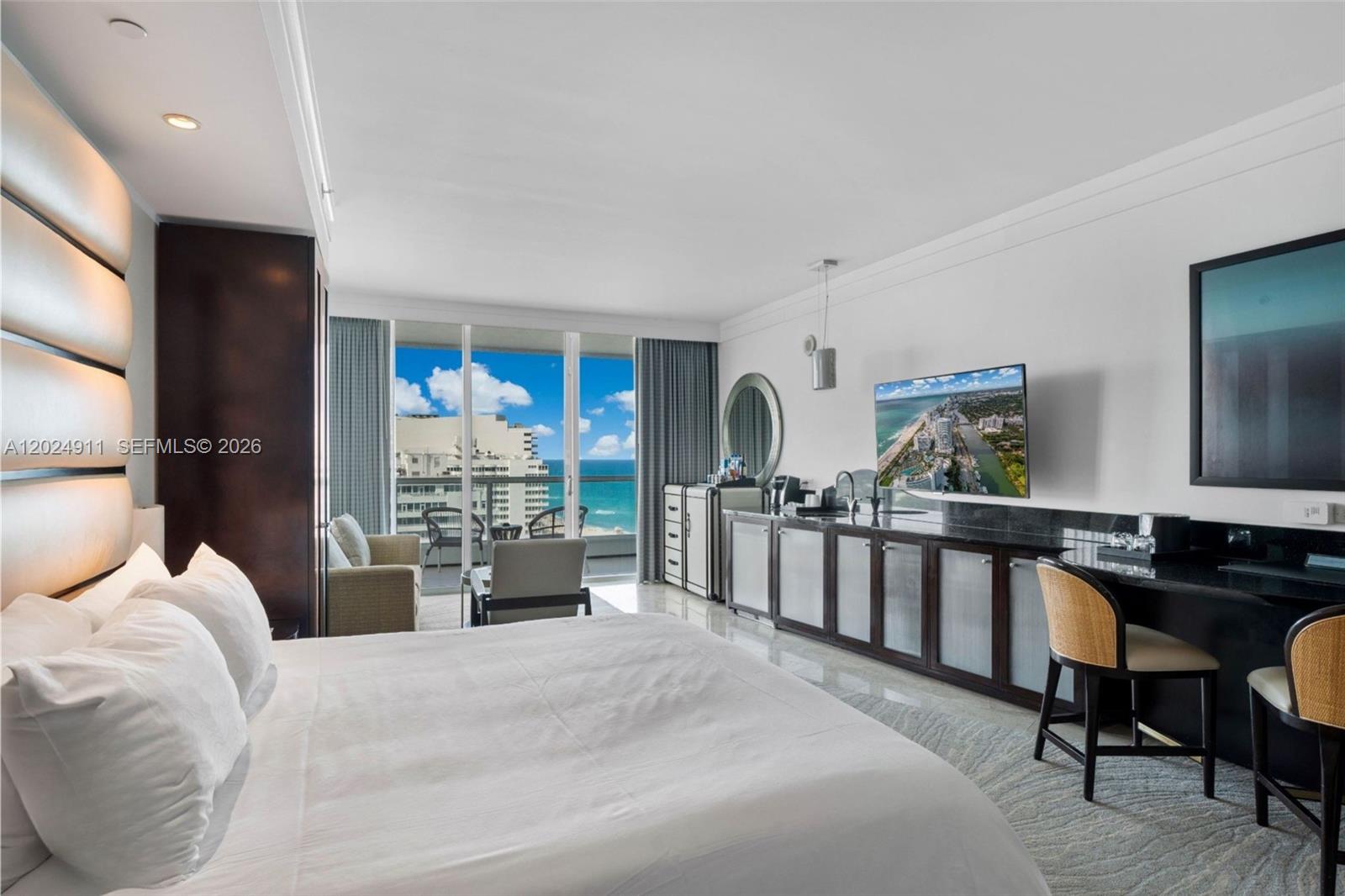 A hotel room features a bed, a desk, a kitchenette, and a balcony overlooking the ocean — 4391 Collins Ave # 1002, Miami Beach FL 33140, MIAMI BEACH, FL