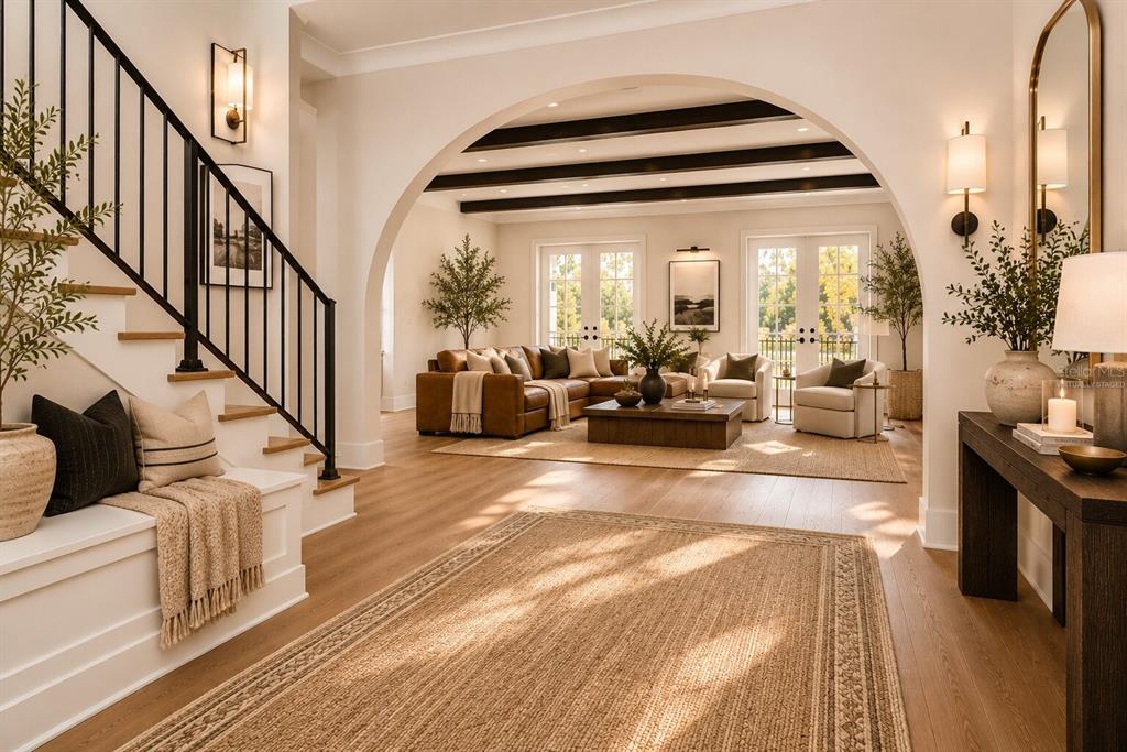 A foyer with a staircase leads through an arched opening into a living room — 4314 W VASCONIA STREET, TAMPA, FL