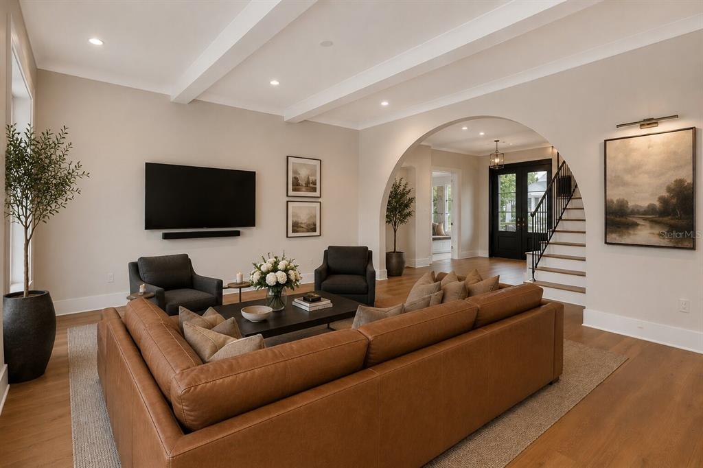 A living room features a leather sectional, two armchairs, a television, and an arched entryway — 4314 W VASCONIA STREET, TAMPA, FL