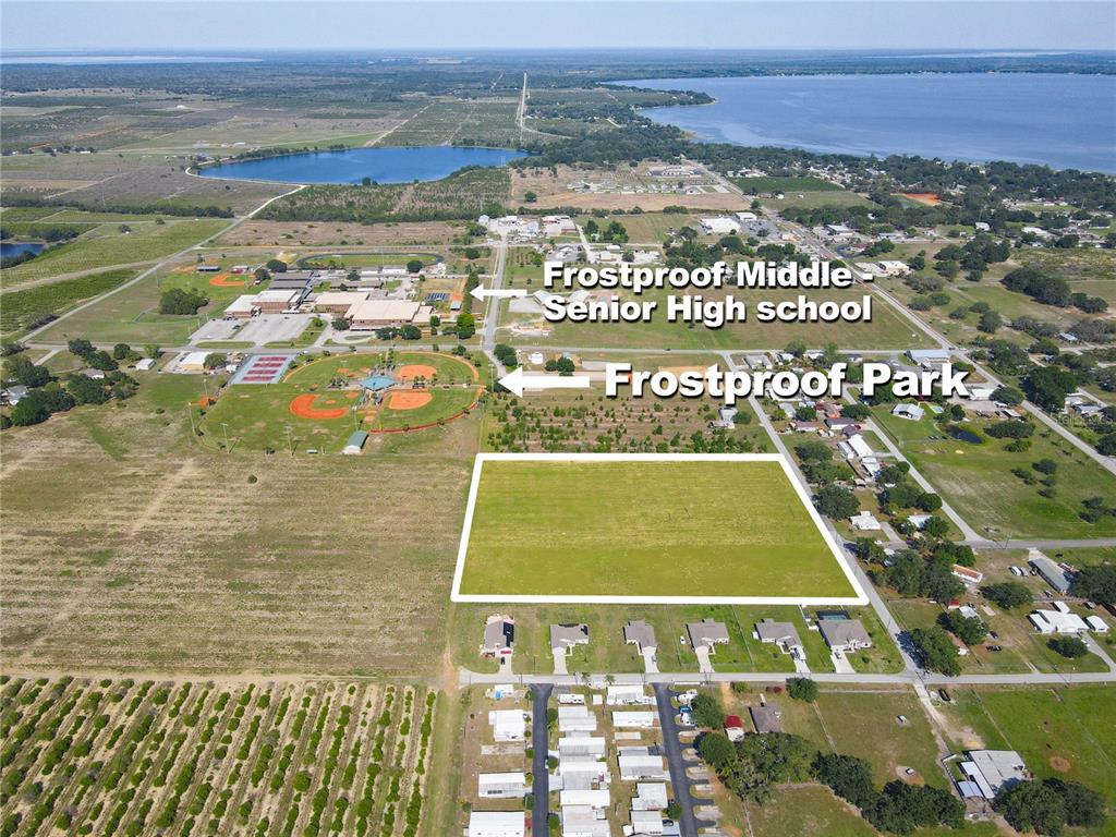 This aerial view shows a vacant rectangular lot near a school and a park — 360 SWINGLE STREET, FROSTPROOF, FL