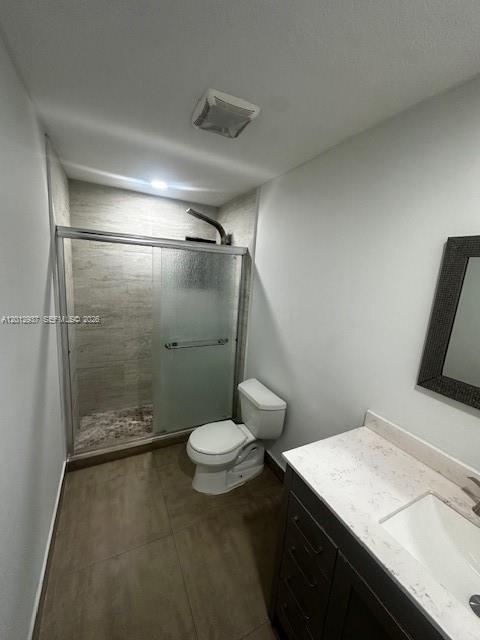 A bathroom featuring a glass-enclosed shower, a white toilet, and a vanity with a countertop — 18560 SW 128th Ave # B, Miami FL 33177, MIAMI, FL