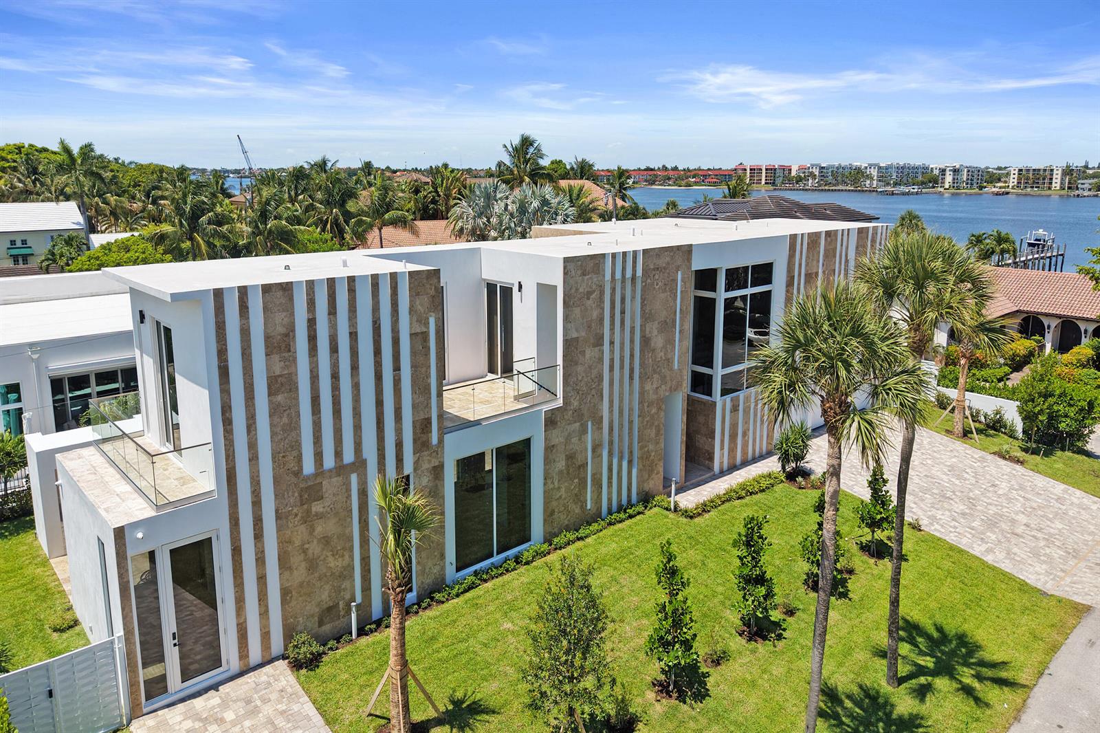 An aerial view of a modern two-story house with stone and white vertical exterior panels — 824 W Marbella Lane, Lantana FL 33462, LANTANA, FL