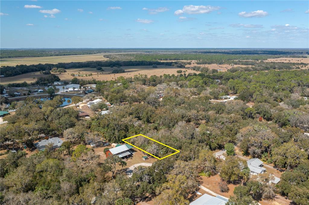 An aerial view shows a wooded residential lot outlined in yellow next to a house — 00 W BEACH PARKWAY UNIT 0, LAKE WALES, FL