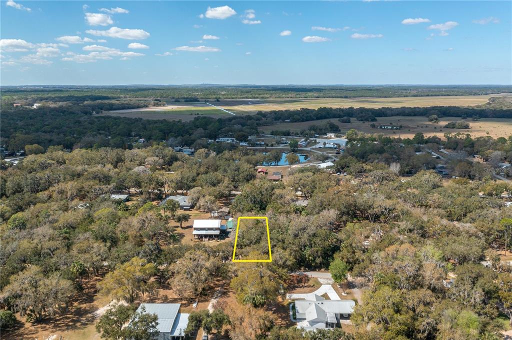An aerial view shows a wooded residential lot outlined in yellow near a rural landscape — 00 W BEACH PARKWAY UNIT 0, LAKE WALES, FL