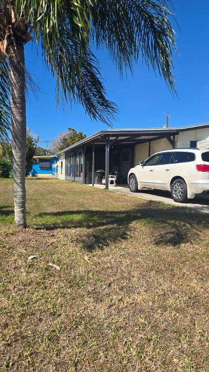 A white SUV is parked under a carport attached to a single-story home — 854 CALLE MENUDA, ENGLEWOOD, FL