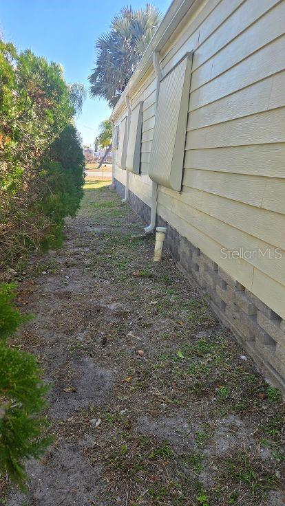 A view of the side exterior of a house with light-colored siding and window awnings — 854 CALLE MENUDA, ENGLEWOOD, FL