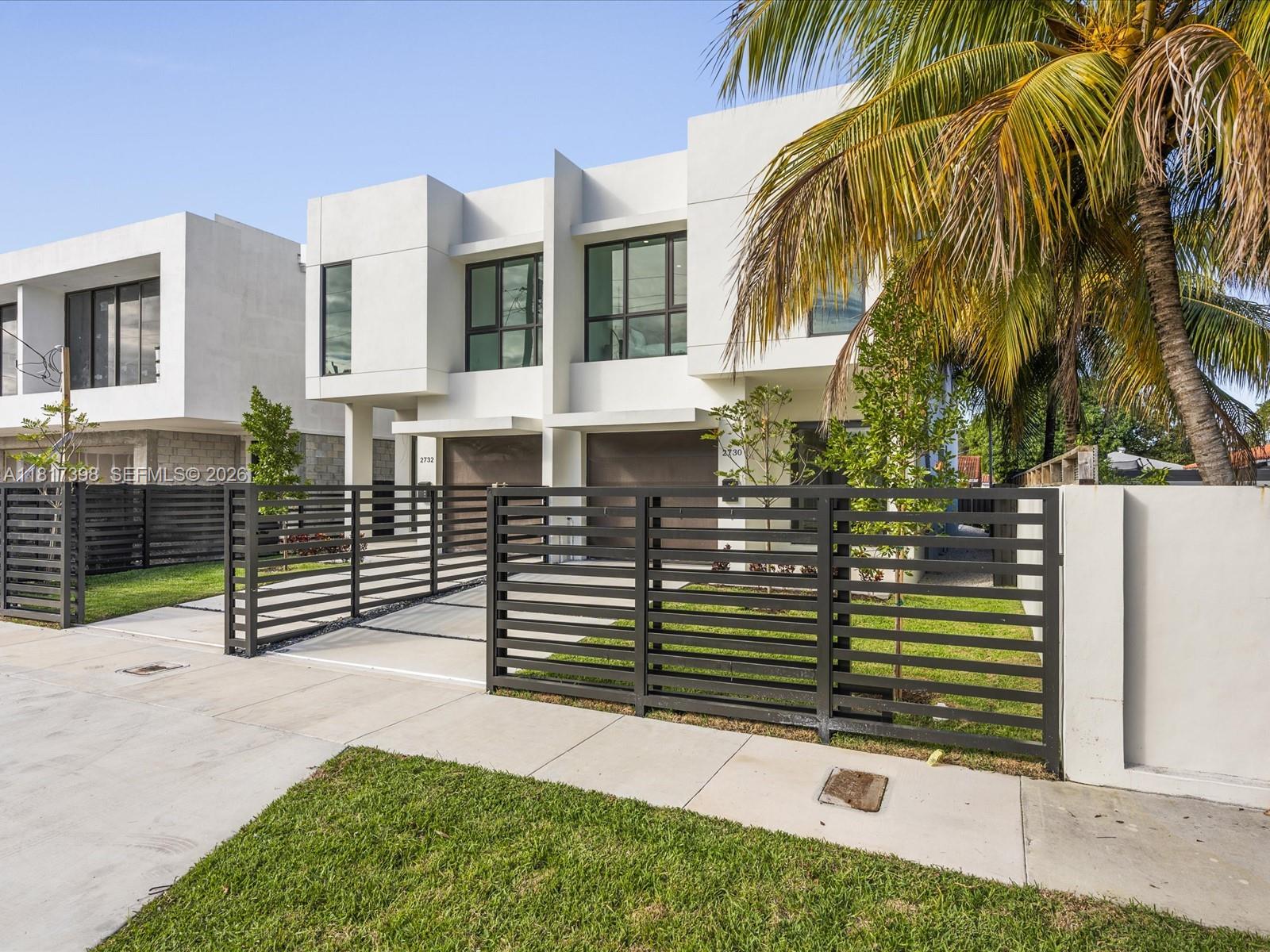 A modern house exterior features a small swimming pool, patio seating, and a black fence — 2732 SW 31st Ave, Miami FL 33133, MIAMI, FL