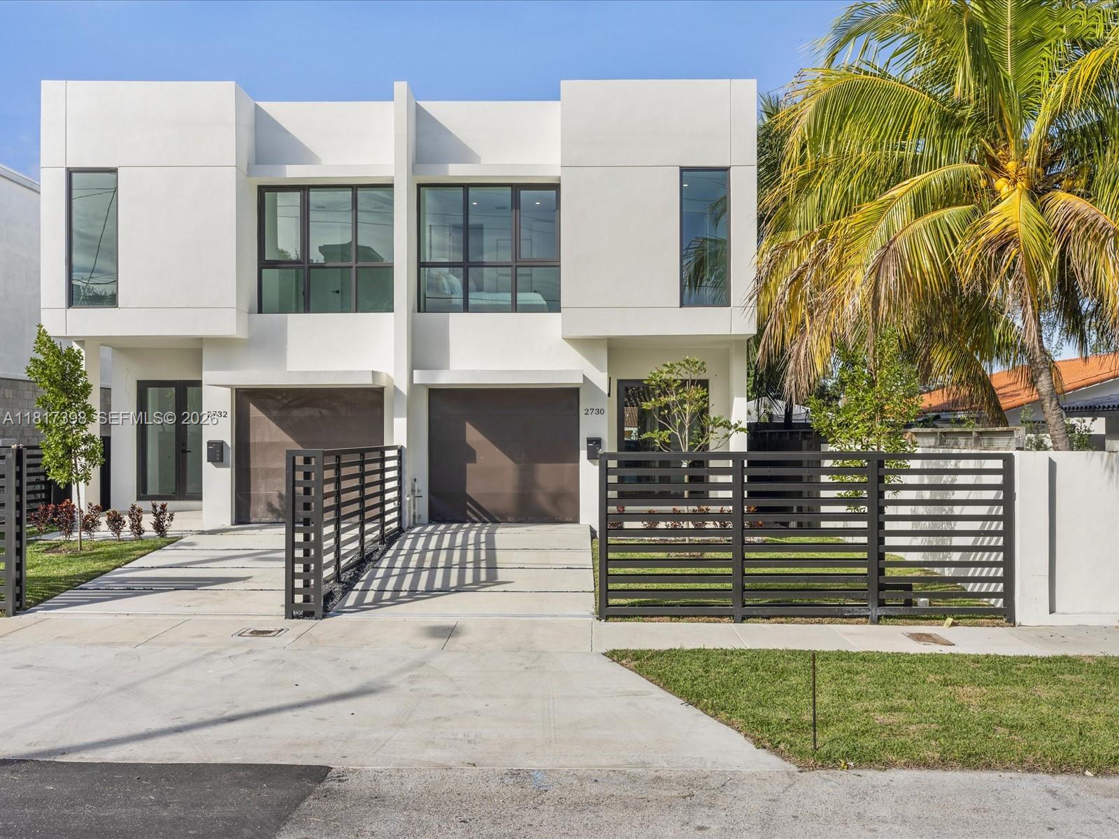 A rectangular swimming pool sits on a patio next to a modern house and fence — 2732 SW 31st Ave, Miami FL 33133, MIAMI, FL
