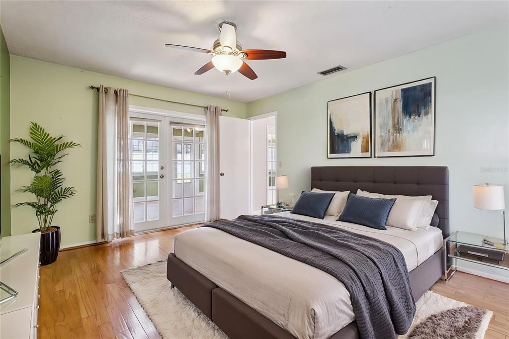A sunroom features wicker furniture, built-in white shelving, and green walls under a skylight — 215 TWELVE LEAGUE CIRCLE, CASSELBERRY, FL