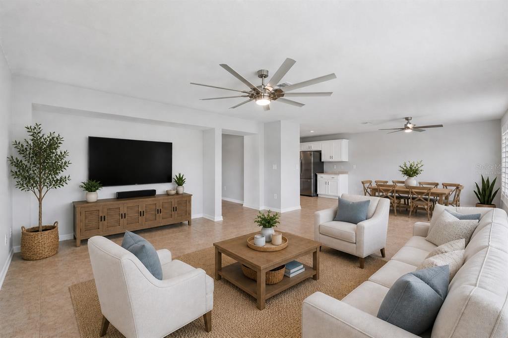 An empty room with light-colored tile flooring, two ceiling fans, and sliding glass doors — 9515 SIMEON DRIVE, LAND O LAKES, FL