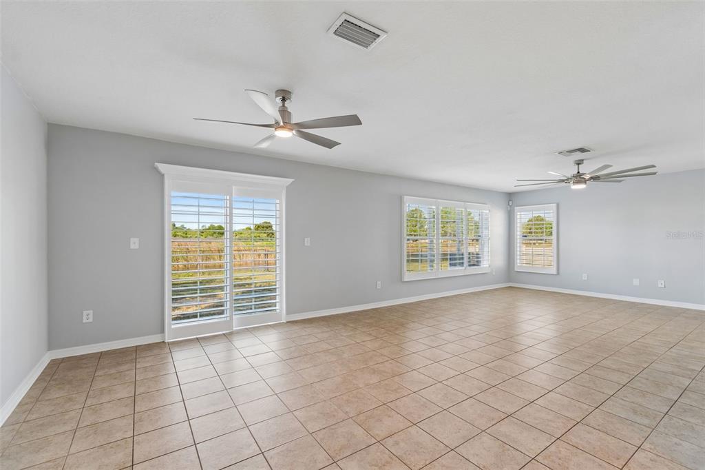 A living room with a television, wooden console, two armchairs, and a sofa — 9515 SIMEON DRIVE, LAND O LAKES, FL