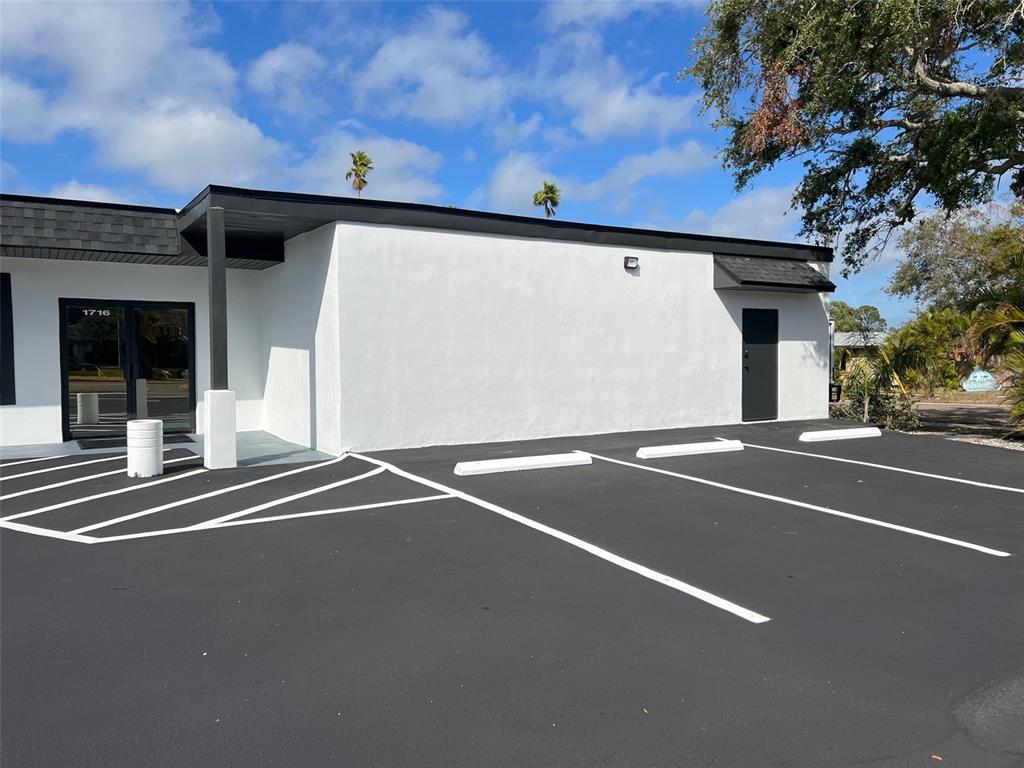 A white commercial building exterior features a black roofline and a paved parking lot — 1710 N FORT HARRISON AVENUE, CLEARWATER, FL
