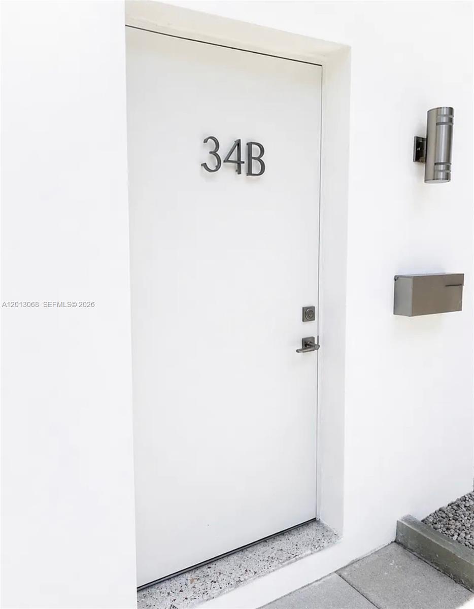 A white exterior door labeled 34B features a wall-mounted light fixture and a metal mailbox — 34 SE 1st Ave # B, Dania Beach FL 33004, DANIA BEACH, FL