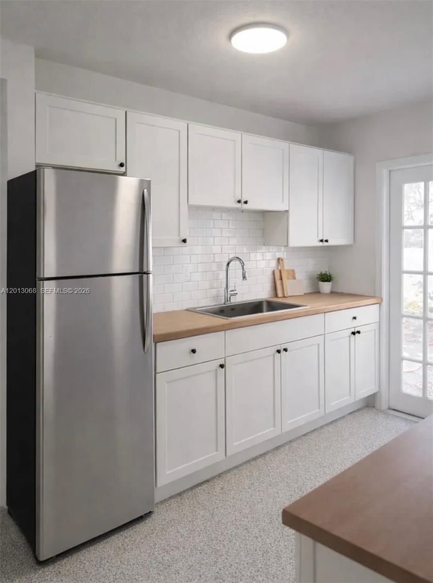 A kitchen features white shaker cabinets, a stainless steel refrigerator, and a wood countertop — 34 SE 1st Ave # B, Dania Beach FL 33004, DANIA BEACH, FL