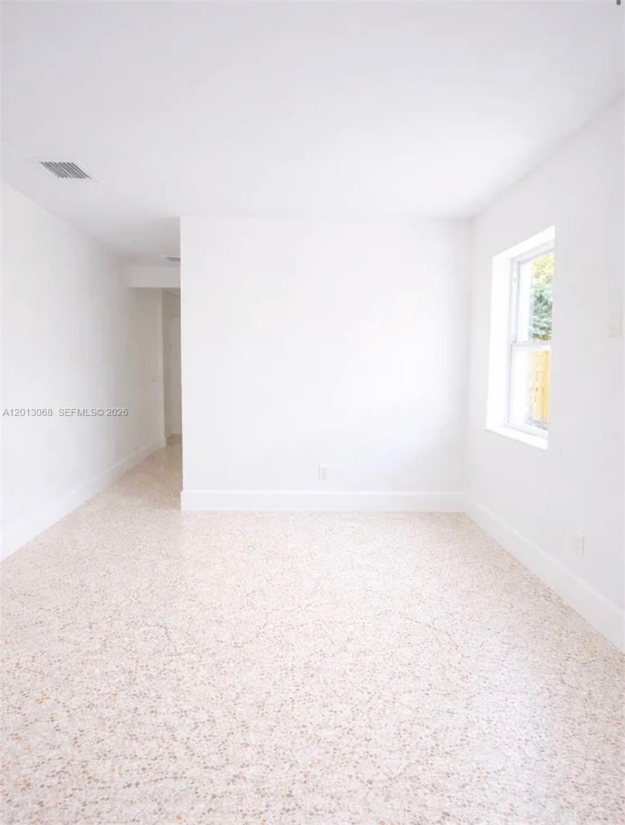 An empty room features white walls, a single window, and light-colored speckled terrazzo flooring — 34 SE 1st Ave # B, Dania Beach FL 33004, DANIA BEACH, FL