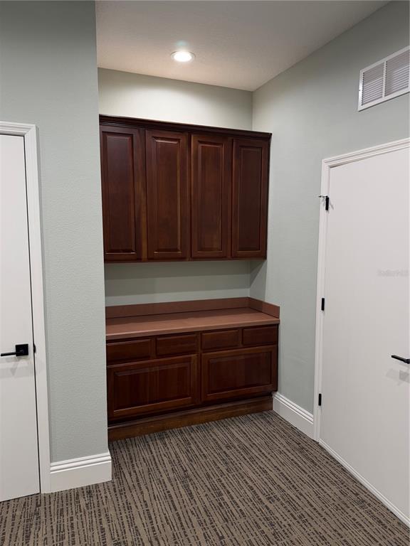 A small room features dark wood cabinetry with a countertop between two white doors — 5182 N OCEAN SHORE BOULEVARD UNIT A-3, PALM COAST, FL