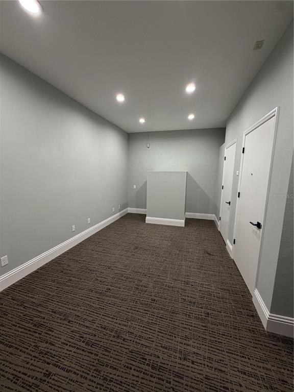 An empty room with light green walls, recessed lighting, and dark patterned carpeting — 5182 N OCEAN SHORE BOULEVARD UNIT A-3, PALM COAST, FL