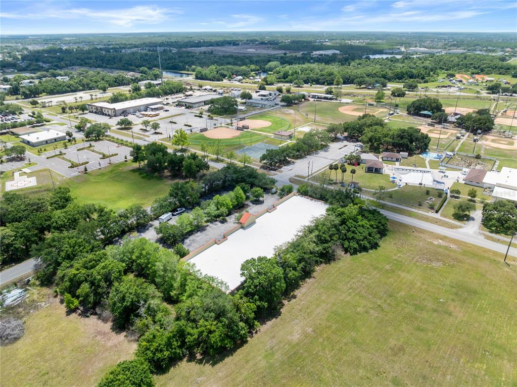 An aerial view shows a commercial building with a white roof surrounded by trees — 3006 17TH STREET, ST CLOUD, FL