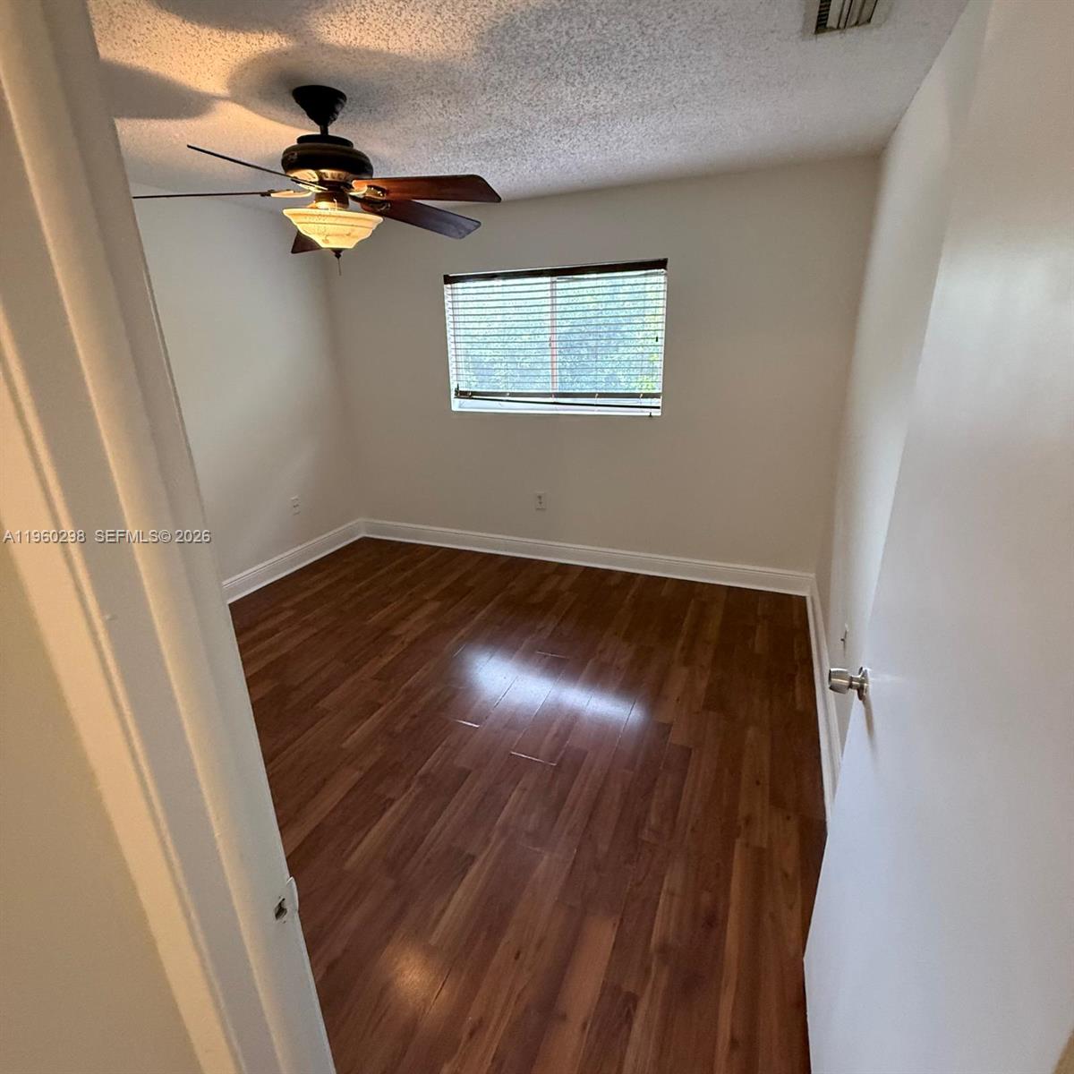 An empty bedroom features wood-look flooring, a ceiling fan, and a window with blinds — 8260 SW 149th Ct # 205, Miami FL 33193, MIAMI, FL