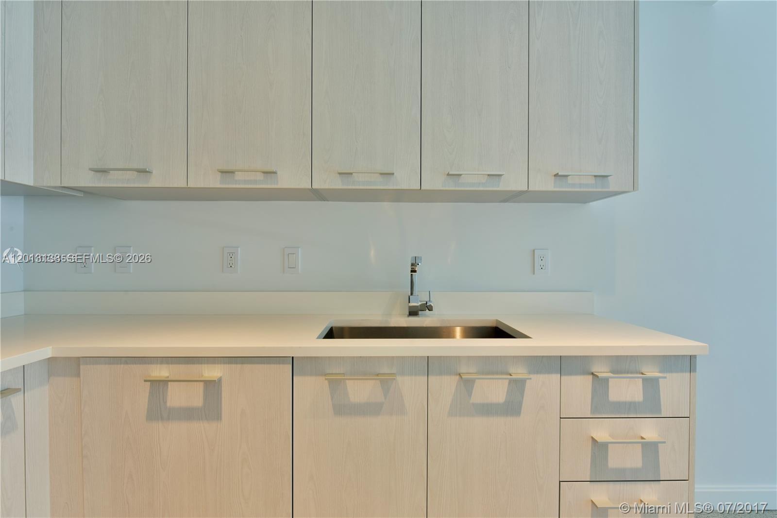 A kitchen features light wood cabinets, a white countertop, and a stainless steel sink — 45 SW 9 st # 1907, Miami FL 33130, MIAMI, FL
