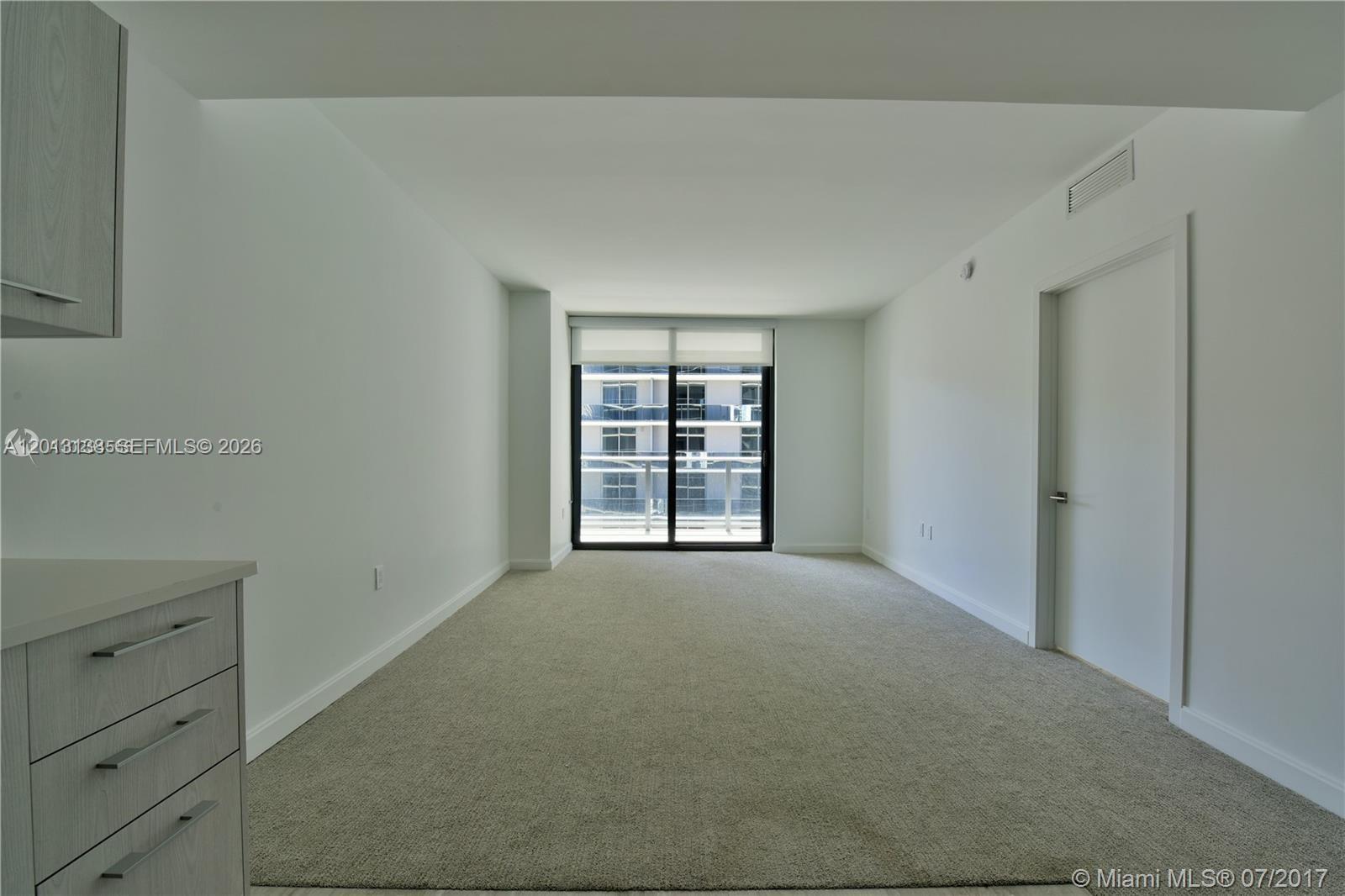 A carpeted room features white walls, a sliding glass door, and light-colored cabinetry — 45 SW 9 st # 1907, Miami FL 33130, MIAMI, FL