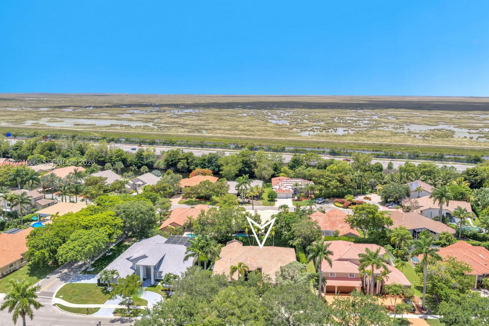 An aerial view shows a residential neighborhood with single-family homes surrounded by trees and wetlands — 1776 W Eagle Trace Blvd W, Coral Springs FL 33071, CORAL SPRINGS, FL