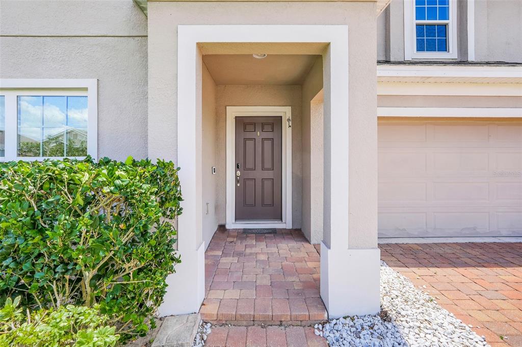 The exterior view shows a front entryway with a brown door and a paver walkway — 639 SAMUEL PLACE, DAVENPORT, FL