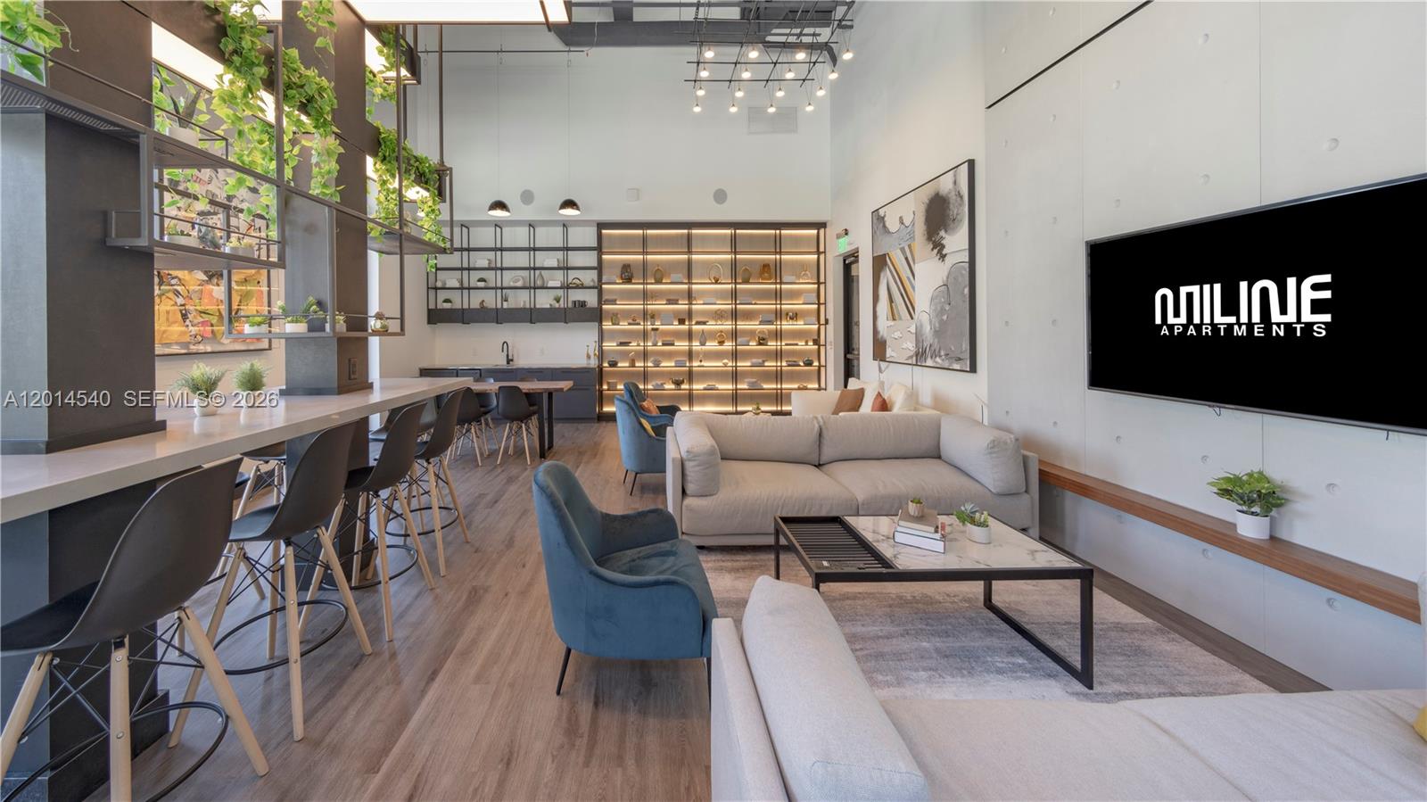 A modern apartment lounge features a bar area, plush seating, and a large wall-mounted television — 6970 SW 40th St # 354, Miami FL 33155, MIAMI, FL