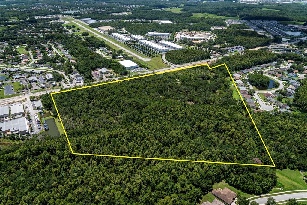 An aerial view shows a large, wooded plot of land outlined in yellow — N/A N/A, LAND O LAKES, FL