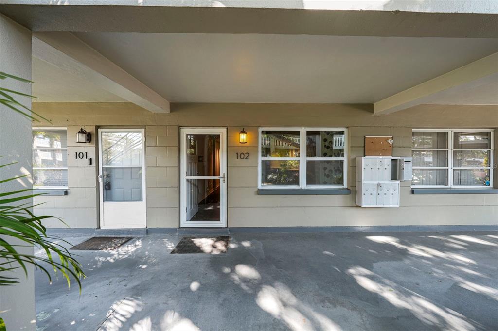 The exterior view shows two apartment entrances labeled 101 and 102 under a covered walkway — 426 32ND AVENUE N UNIT 102E, ST PETERSBURG, FL