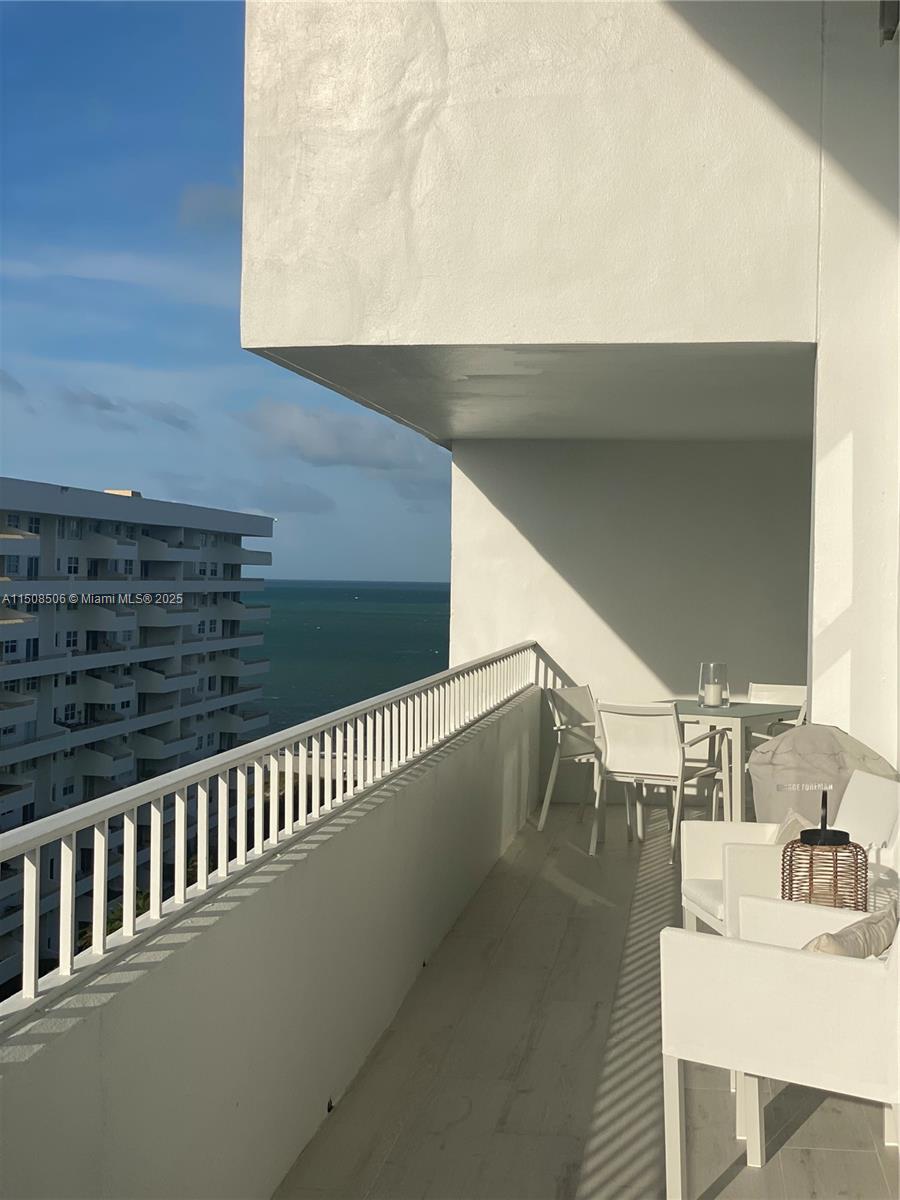 A white balcony overlooks the ocean with outdoor furniture and a grill — 199 Ocean Lane Dr # 1112, Key Biscayne FL 33149, KEY BISCAYNE, FL