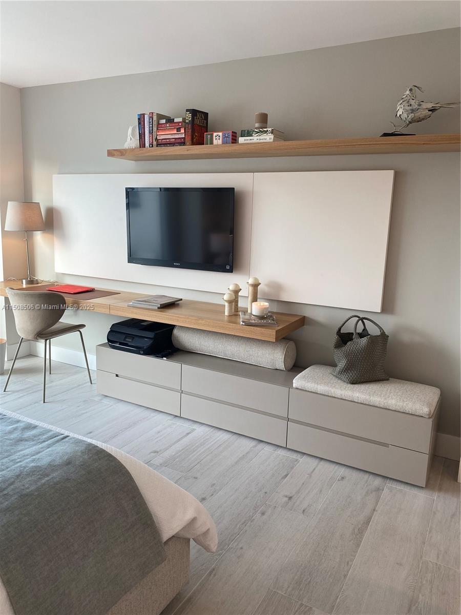 A bedroom features a wall-mounted television, a floating desk, and built-in storage cabinets — 199 Ocean Lane Dr # 1112, Key Biscayne FL 33149, KEY BISCAYNE, FL