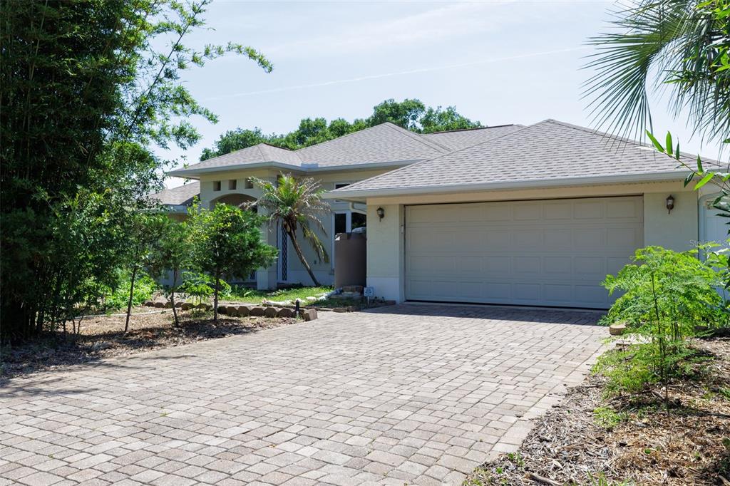A single-story house with a paved driveway, a two-car garage, and surrounding landscaping — 6 FAIRHILL LANE, PALM COAST, FL