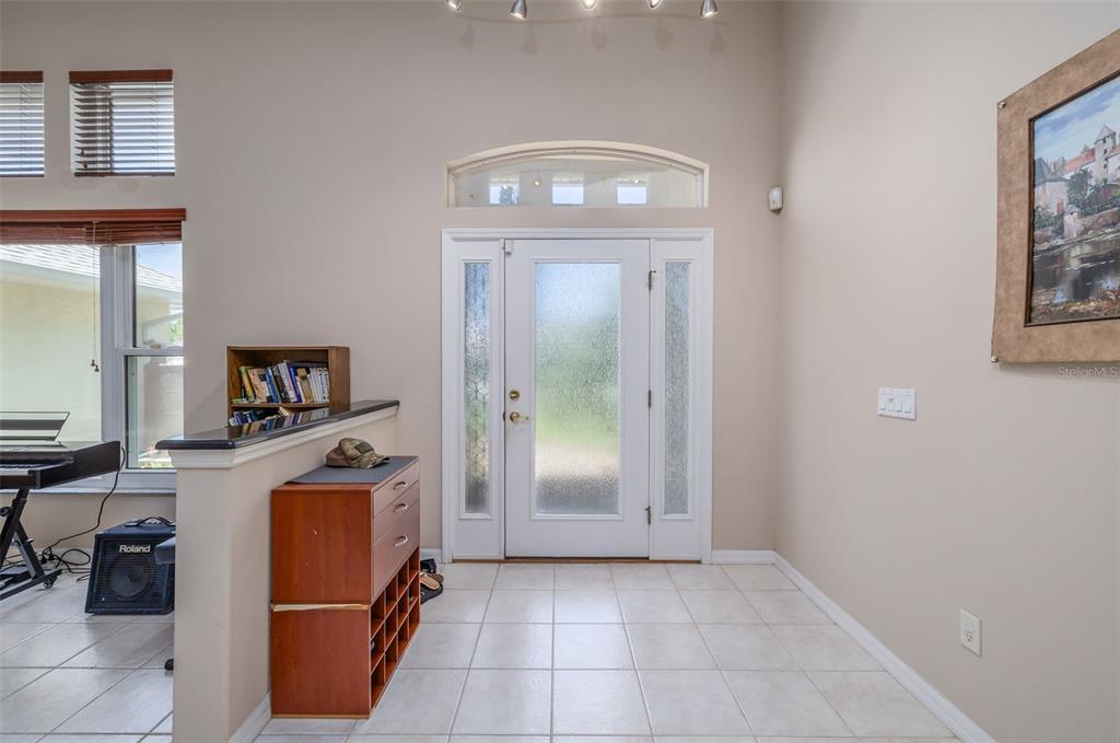 An entryway features a white front door with glass panels, tile flooring, and a half-wall — 6 FAIRHILL LANE, PALM COAST, FL