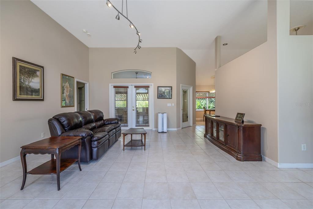 A living room features tile flooring, a brown leather sofa, and a wooden media console — 6 FAIRHILL LANE, PALM COAST, FL