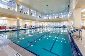 An indoor swimming pool with multiple lap lanes, large windows, and a tiled deck — 235 ANASTASIA DRIVE, POINCIANA, FL