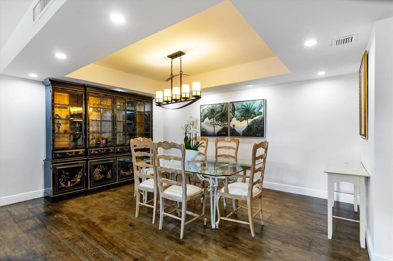 A dining room features a glass-top table, wooden chairs, a black hutch, and recessed lighting — 2860 S Ocean Boulevard # 214, Palm Beach FL 33480, PALM BEACH, FL