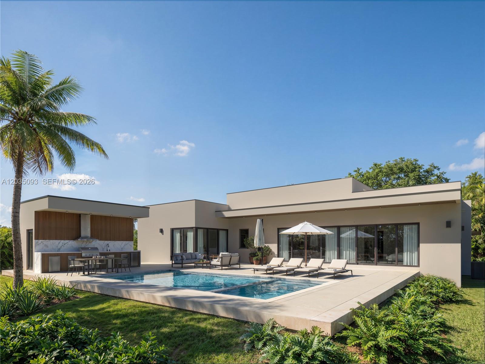 A modern house features a swimming pool, outdoor kitchen, and lounge area on a patio — 9445 SW 73rd Ave, Pinecrest FL 33156, PINECREST, FL