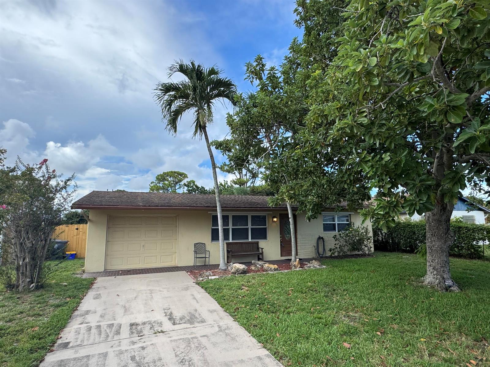 A backyard features a swimming pool with a black fence and two mature trees — 4353 Broadway Street, Lake Worth FL 33461, LAKE WORTH, FL