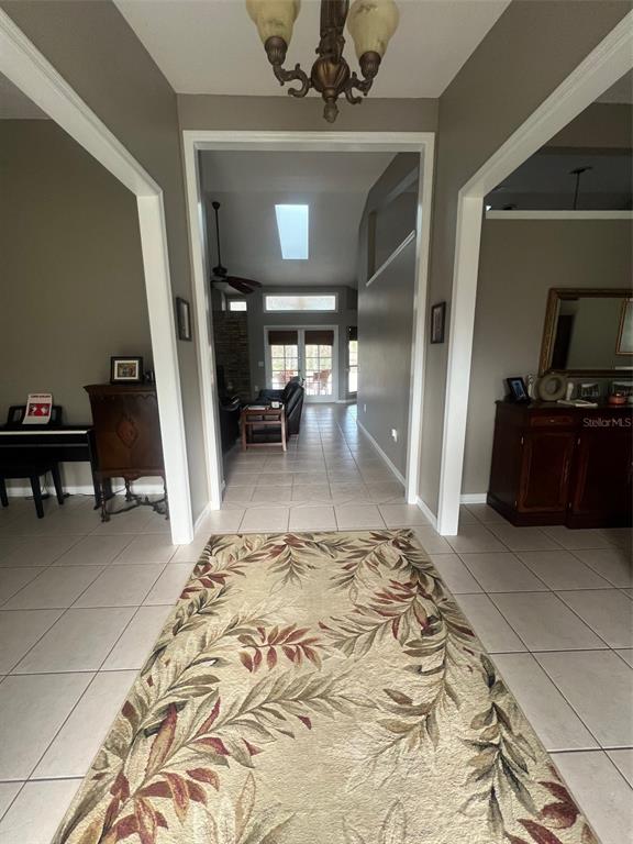 A tiled entryway leads through a wide doorway into a living area with a skylight — 1545 ANTOINETTE COURT, OVIEDO, FL