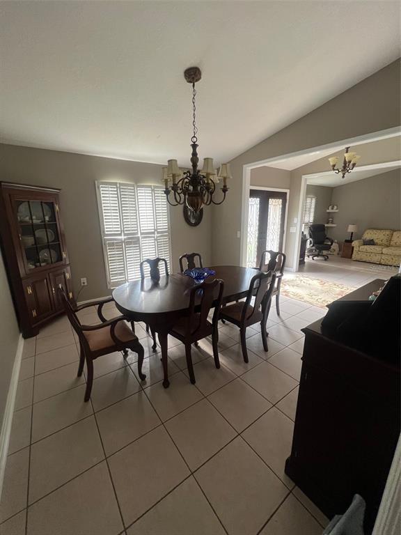 A dining room features a dark wood table, six chairs, a chandelier, and tile flooring — 1545 ANTOINETTE COURT, OVIEDO, FL