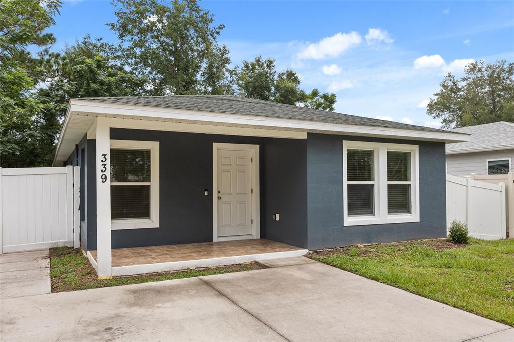 A dark gray single-story house features a covered front porch and a concrete driveway — 339 CHINABERRY AVENUE, OVIEDO, FL